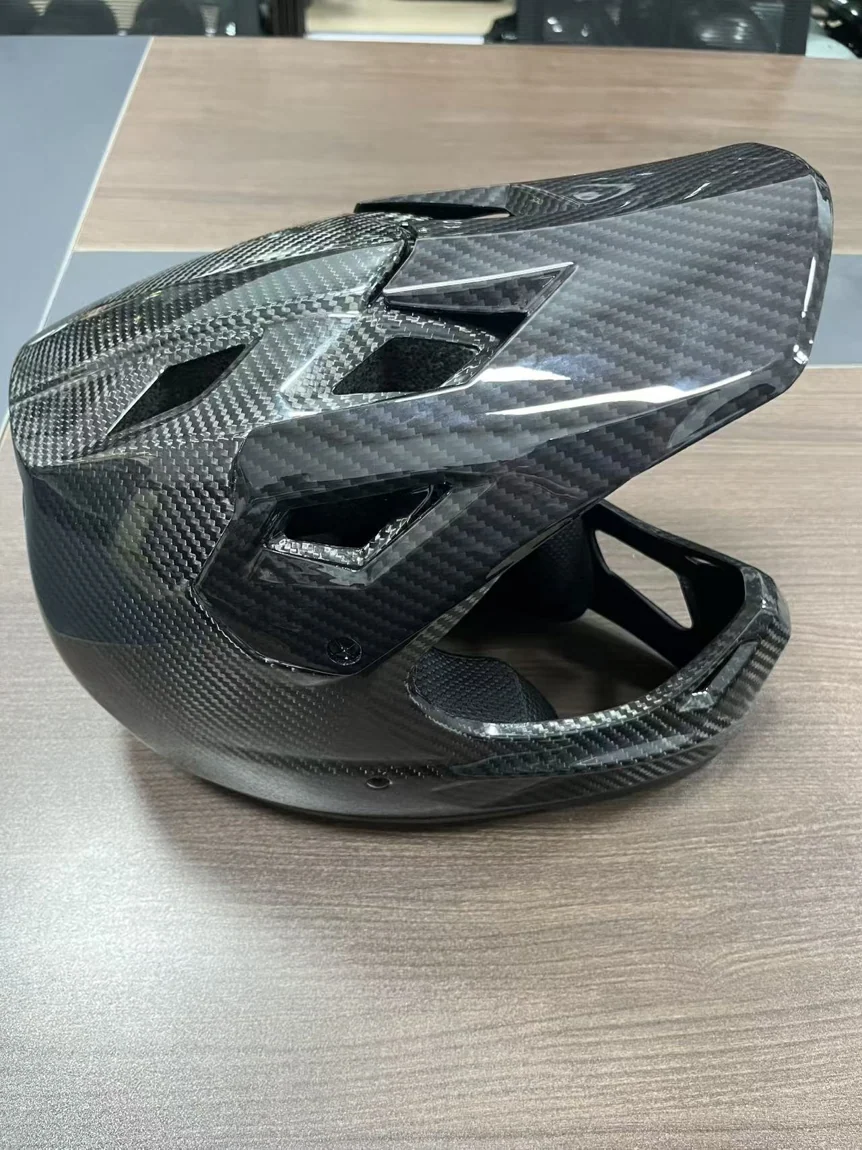 Finished molded carbon fiber helmet shell showing the surface and weave of the manufactured component